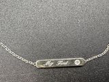 a close up of a silver necklace with a name on it