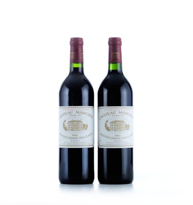 deux bouteilles de vin rouge posées l'une à côté de l'autre sur une surface blanche