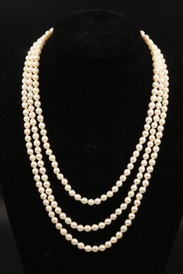 a three strand pearl necklace on a mannequin display