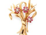 une image représentant une broche en or sertie de pierres roses et blanches
