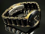 une montre noire et dorée posée sur une surface noire