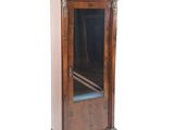 une petite armoire en bois munie d'une porte vitrée