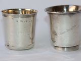 une paire de tasses en métal argenté sur lesquelles sont gravés des noms