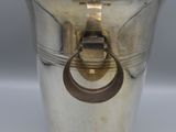 a silver vase with a ring handle on it