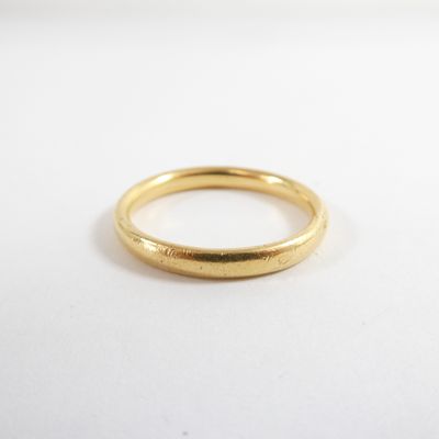 gros plan d'une bague en or sur une surface blanche