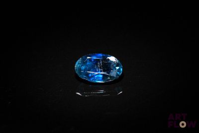 a close up of a blue sapphire stone on a black surface