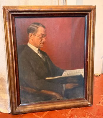 tableau représentant un homme en train de lire un livre posé sur une table devant un mur