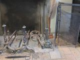 a fire place with a bunch of tools on the floor