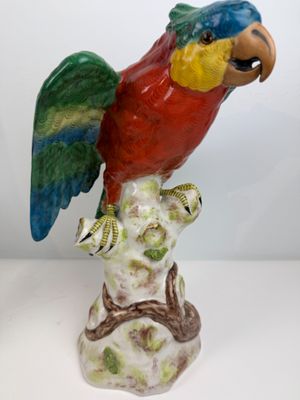 a figurine of a parrot sitting on top of a branch