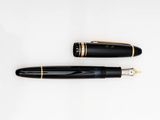 the pen is black with gold trims and has a black nib