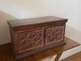 an old wooden chest sitting on top of a table next to a lamp