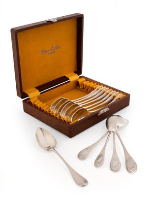 un service en argent dans un coffret en bois contenant des cuillères