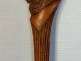 une photo représentant une sculpture en bois représentant une tête de lion fixée sur un bâton