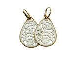a pair of gold earrings with a white tear shaped design