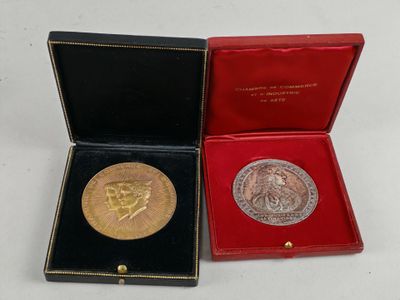 une médaille d'or dans un coffret rouge posé sur un fond blanc