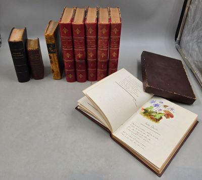 Plusieurs vieux livres sont posés sur une table près d'une fenêtre