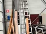 many pieces of wood and a ladder in a warehouse