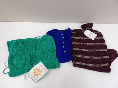 trois paires de pulls sont posées sur une surface blanche