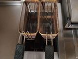 two baskets of frying pans hanging from the ceiling