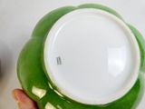 une personne tenant un bol vert et blanc dans la main