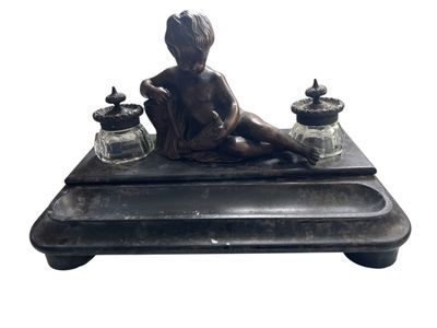 statue représentant un garçon assis sur un plateau sur lequel sont posés des jarres