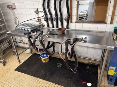 une cuisine équipée d'un évier et d'un plan de travail avec de nombreux tuyaux