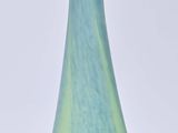 a blue and green vase sitting on a white surface