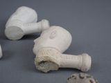 three pieces of pottery sitting on a table next to a baseball mitt