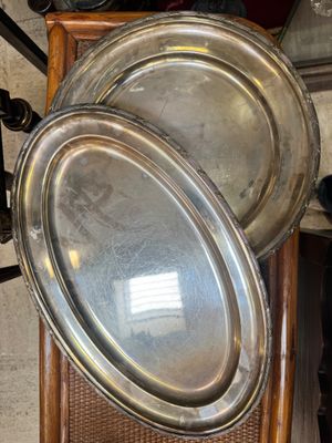 deux plateaux en argent posés sur une chaise en bois