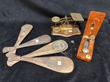 five antique wooden spoons and a scale on a black cloth