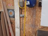 a picture of a room with a bucket and a hose attached to the wall