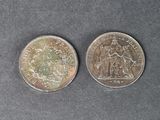 deux pièces d'argent posées côte à côte sur une surface grise
