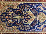 an image of a blue and red rug with a floral design on it
