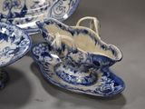 three blue and white plates and a bowl on a table