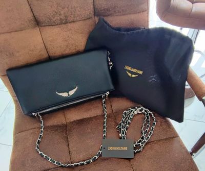 un sac noir et un sac à main noir posés sur une chaise
