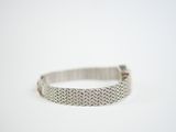 a close up of a silver bracelet on a white surface