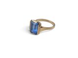 a close up of a gold ring with a blue stone
