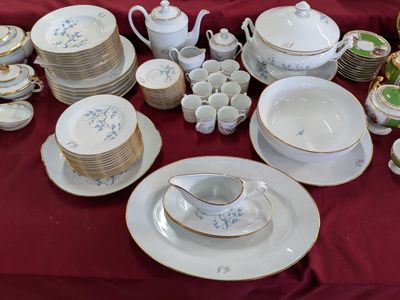 de nombreuses assiettes et tasses sur une table recouverte d'une nappe rouge