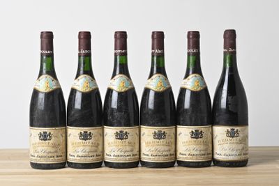 six bouteilles de vin sont alignées sur une table en bois