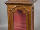 une vieille horloge en bois surmontée d'un couvercle en verre rouge