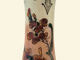 un vase orné d'un motif de fleurs et de papillons