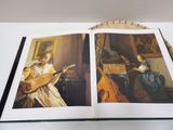 an open book with a picture of a woman playing a mandolin