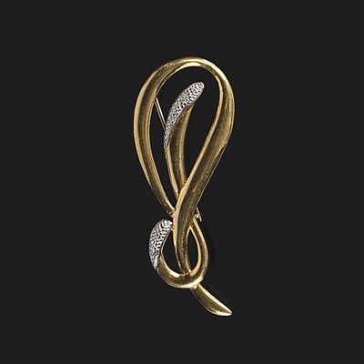 une image représentant une broche en or et diamants sur fond noir