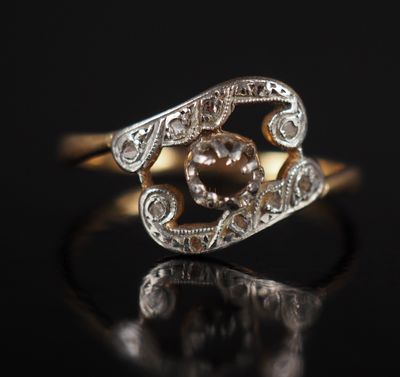 a close up of a gold and diamond ring on a black surface
