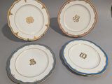 quatre assiettes ornées de motifs dorés et bleus, posées sur une table