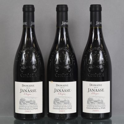 Trois bouteilles de vin rouge sont alignées sur une table en verre