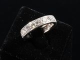 a close up of a diamond ring on a black velvet surface