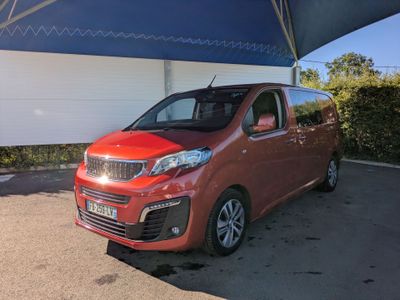 Une voiture rouge est garée sous un auvent bleu et blanc.