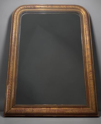 an antique gold framed mirror with a black background