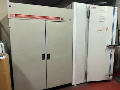 a large white refrigerator sitting in a room next to a pile of boxes